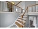 Open staircase with wooden railing, overlooking living area with fireplace at 204 Swamp Fox Dr, Fort Mill, SC 29715