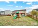 Large backyard with a playset, pergola-covered patio, and fenced yard at 2065 Taney Way, Fort Mill, SC 29707