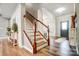 Hardwood staircase leading to the upper level, with a view of the home's entry at 2065 Taney Way, Fort Mill, SC 29707