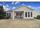 Back exterior featuring a covered patio, well-manicured lawn, and mature trees at 23234 Kingfisher Dr, Indian Land, SC 29707