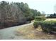 Well-manicured landscaping and an iron fence frame a gravel path adjacent to lush greenery, enhancing the property's appeal at 23234 Kingfisher Dr, Indian Land, SC 29707