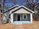 Inviting gray home with black door, white trim, and covered front porch at 238 Coxe Ave, Charlotte, NC 28208