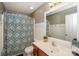 Well-lit bathroom with vanity, large mirror, and a shower with patterned curtain at 265 Sutro Forest Nw Dr, Concord, NC 28027