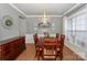 Formal dining room with wainscoting, a modern chandelier, and a large window for natural light at 265 Sutro Forest Nw Dr, Concord, NC 28027