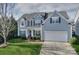Charming two-story home with blue siding, a two-car garage, manicured lawn and lovely landscaping at 265 Sutro Forest Nw Dr, Concord, NC 28027