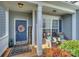 Inviting front porch with stylish seating, a 'welcome' sign, and a wreath on a dark blue front door at 265 Sutro Forest Nw Dr, Concord, NC 28027