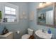 Light blue powder room with decorative mirror, pedestal sink, and wainscoting accents at 265 Sutro Forest Nw Dr, Concord, NC 28027