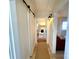 Bright hallway with barn door, light wood floors, and view of living room at 2704 Kool Park Ne Rd, Hickory, NC 28601