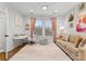 Bright bedroom with taupe sofa, pink accents and home office space at 305 Ideal Way, Charlotte, NC 28203