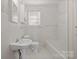 Clean bathroom with white tiled shower, marble floors, and updated fixtures at 3724 Commonwealth Ave, Charlotte, NC 28205