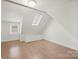 Spacious attic bedroom featuring hardwood floors, skylight, and built-in storage at 3724 Commonwealth Ave, Charlotte, NC 28205