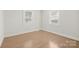 Light filled bedroom with hardwood floors, neutral paint, and two windows at 3724 Commonwealth Ave, Charlotte, NC 28205