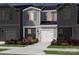 Two-story townhome with gray siding, white garage door, and landscaping at 5042 Kellaher Pl, Charlotte, NC 28216