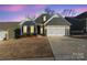 Evening view of gray two-story house with a two-car garage at 5066 Summer Surprise Ln, Charlotte, NC 28215