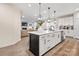 Modern kitchen with white cabinets, large island, and stainless steel appliances at 5066 Summer Surprise Ln, Charlotte, NC 28215