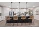 Modern kitchen island with four wicker chairs, stainless steel appliances, and white cabinets at 5066 Summer Surprise Ln, Charlotte, NC 28215