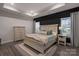 Main bedroom with king bed, light wood dresser and dark accent wall at 5066 Summer Surprise Ln, Charlotte, NC 28215