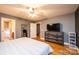 Main bedroom with hardwood floors, dresser, and large TV at 5241 Whitewater Dr, Hickory, NC 28601