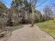 Landscaped backyard with gravel pathway, mature trees, and bird bath at 616 N Oak Dr, Huntersville, NC 28078