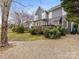 Gray house exterior with deck, mature trees, and a gravel driveway at 616 N Oak Dr, Huntersville, NC 28078