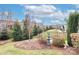 Lush backyard featuring well-manicured landscaping, ornamental water fountain, and elegant black fencing at 6248 Raven Rock Dr, Denver, NC 28037