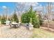 Stone patio with a dining table, grill, and views of the lush, well-maintained backyard and landscaping at 6248 Raven Rock Dr, Denver, NC 28037