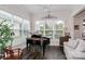 Bright sunroom with a grand piano, lots of windows and comfortable seating at 6248 Raven Rock Dr, Denver, NC 28037