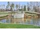 Community water feature with stacked stone, landscaping, and a pond at 6248 Raven Rock Dr, Denver, NC 28037