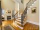 Grand foyer with hardwood floors, staircase with iron railing, and fireplace at 6926 Linkside Ct, Charlotte, NC 28277