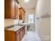 Laundry room with wooden cabinets and granite countertop at 6926 Linkside Ct, Charlotte, NC 28277