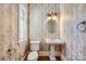 Elegant powder room features a pedestal sink, decorative wallpaper, and hardwood floors at 6926 Linkside Ct, Charlotte, NC 28277