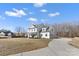 Two-story white farmhouse with a long driveway and landscaped lawn at 8788 Potter Rd, Matthews, NC 28104