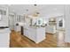 Open kitchen with white cabinets, a large island, and hardwood floors at 8788 Potter Rd, Matthews, NC 28104