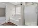 Bright bathroom features a soaking tub, and a shower with glass door at 888 Brevard Place Rd, Iron Station, NC 28080