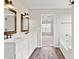 Bright bathroom features a double sink vanity with white cabinets, framed mirrors, and wood-look flooring at 888 Brevard Place Rd, Iron Station, NC 28080