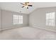 Spacious bedroom with neutral walls and carpet, and two windows at 888 Brevard Place Rd, Iron Station, NC 28080