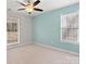 Spacious and bright bedroom showcasing two large windows, neutral carpet, and soft teal wall, creating a serene space at 888 Brevard Place Rd, Iron Station, NC 28080