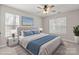 This staged bedroom features carpet, two windows, and ceiling fan at 888 Brevard Place Rd, Iron Station, NC 28080