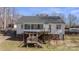 Home's exterior with a sunroom, deck, and access stairs, offering a blend of indoor-outdoor living at 888 Brevard Place Rd, Iron Station, NC 28080