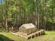 A greenhouse and chicken coop in the backyard surrounded by lush trees and greenery at 888 Brevard Place Rd, Iron Station, NC 28080
