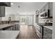 This living room features stainless steel appliances, gray cabinets, wood-look flooring, and natural light at 888 Brevard Place Rd, Iron Station, NC 28080