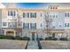 Two-story townhome with stone and siding exterior, landscaping, and a concrete walkway at 9115 Bluefield St, Charlotte, NC 28273