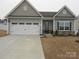 Gray exterior boasts a two-car garage and well-manicured lawn at 106 Milliner Dr # 97, Troutman, NC 28166