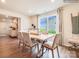 Dining room with light wood table, beige chairs, and view to backyard at 11027 Daisy Ct, Charlotte, NC 28262