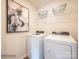 Bright laundry room with washer, dryer, and overhead shelving at 11027 Daisy Ct, Charlotte, NC 28262