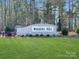 Stone entrance sign for Walkers Mill, surrounded by lush landscaping and towering pine trees at 1171 Blackburn Cir, Edgemoor, SC 29712