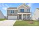 Two-story home with stone accents, gray siding, covered porch, and an attached two-car garage at 1171 Blackburn Cir, Edgemoor, SC 29712