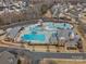 An aerial view captures the community pool, water park features, pool house, and surrounding residential area at 120 Trelawn St, Fort Mill, SC 29715