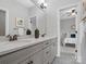 Bathroom with double sinks, gray cabinets, and a view into the bedroom at 120 Trelawn St, Fort Mill, SC 29715