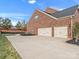 View of exterior highlighting three-car garage and landscaped yard at 120 Trelawn St, Fort Mill, SC 29715